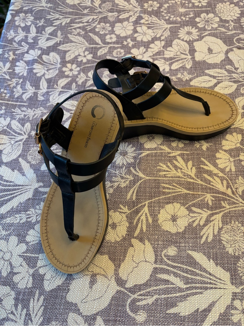 Black T‑Strap Sandals with Tan Footbed, some wear on the soles of the sandal.